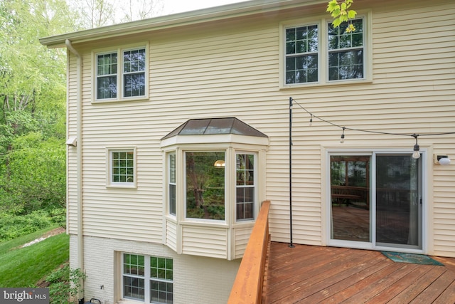 back of house with a deck and brick siding