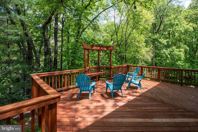wooden terrace featuring a wooded view
