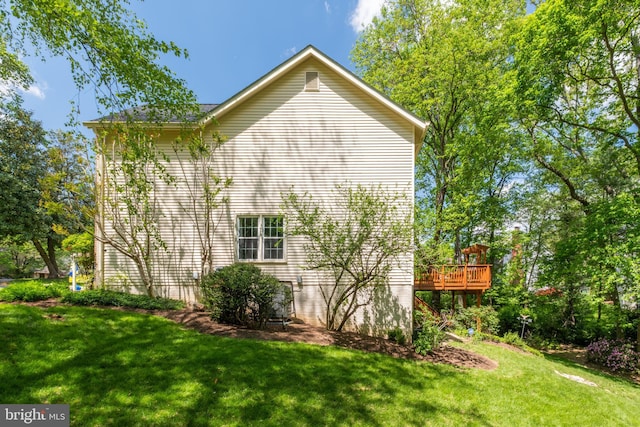 view of side of home with a lawn and a wooden deck