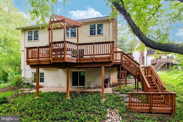 rear view of house featuring stairway, a patio, and a wooden deck