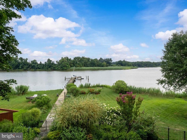 property view of water featuring fence, a boat dock, and boat lift