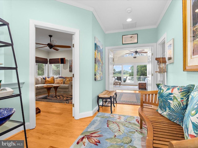 sitting room with wood finished floors, a ceiling fan, and a healthy amount of sunlight
