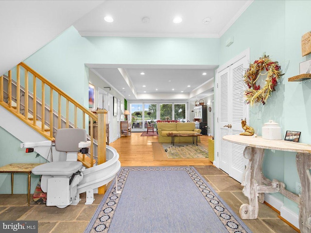 entryway featuring a tray ceiling, stairs, ornamental molding, and recessed lighting