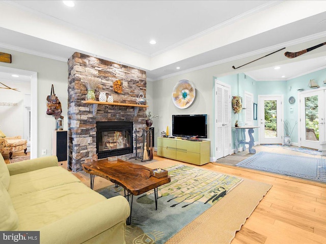 living room featuring crown molding, a fireplace, recessed lighting, wood finished floors, and baseboards