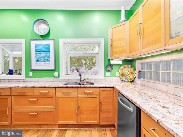 kitchen featuring light wood finished floors, light stone counters, dishwasher, and a sink