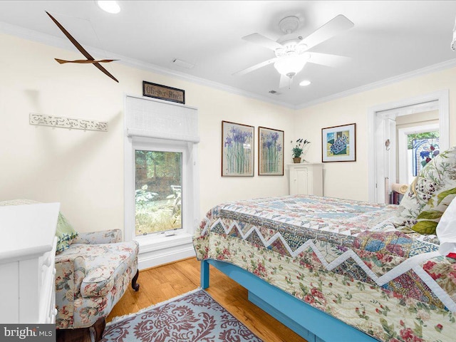 bedroom featuring crown molding, wood finished floors, and multiple windows