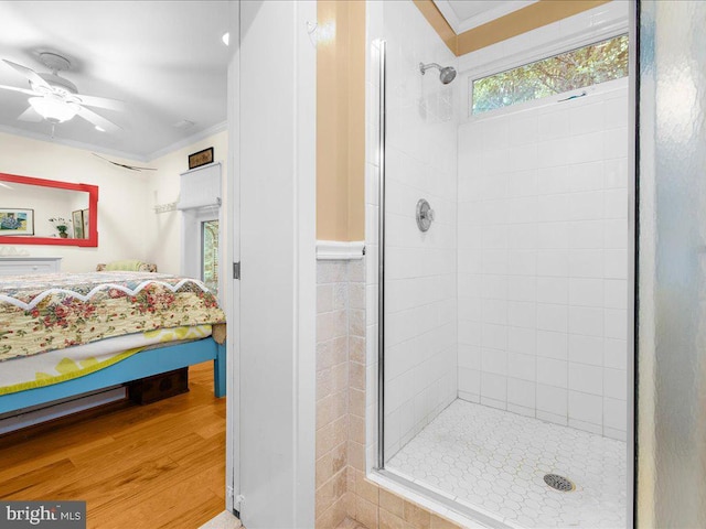full bathroom featuring a shower stall, ceiling fan, crown molding, and wood finished floors