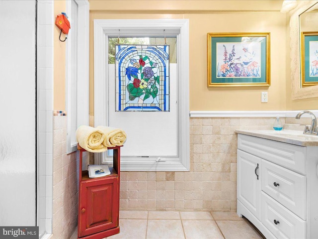 bathroom with wainscoting, vanity, tile patterned flooring, and tile walls
