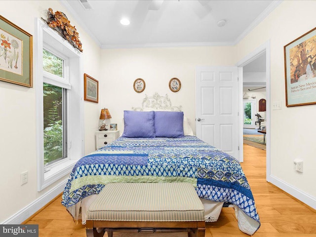 bedroom featuring light wood finished floors, baseboards, and ornamental molding