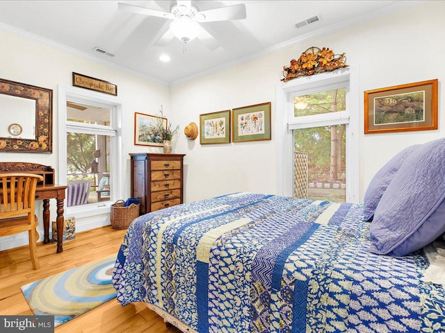 bedroom with ornamental molding, a ceiling fan, visible vents, access to exterior, and wood finished floors