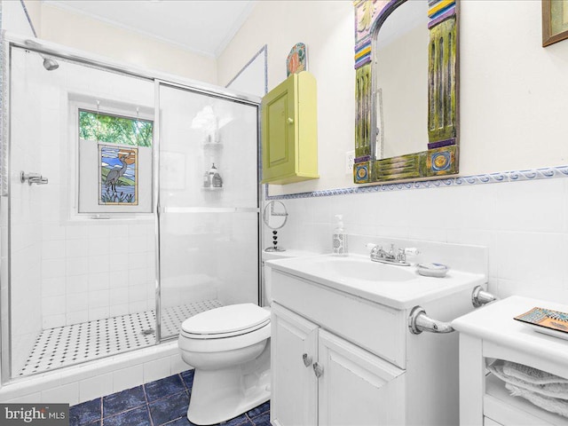 bathroom with ornamental molding, toilet, tile walls, a shower stall, and vanity
