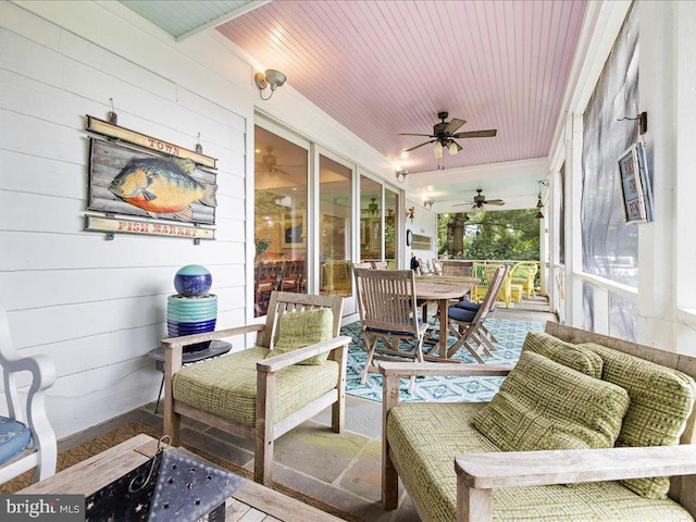 sunroom / solarium with outdoor dining space and a ceiling fan