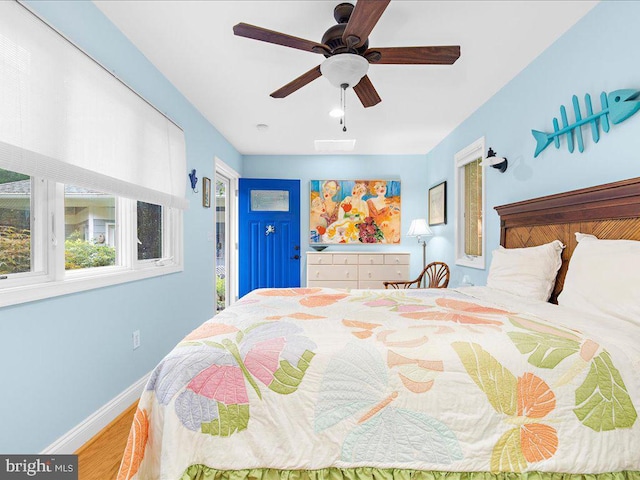 bedroom with visible vents, baseboards, a ceiling fan, and wood finished floors