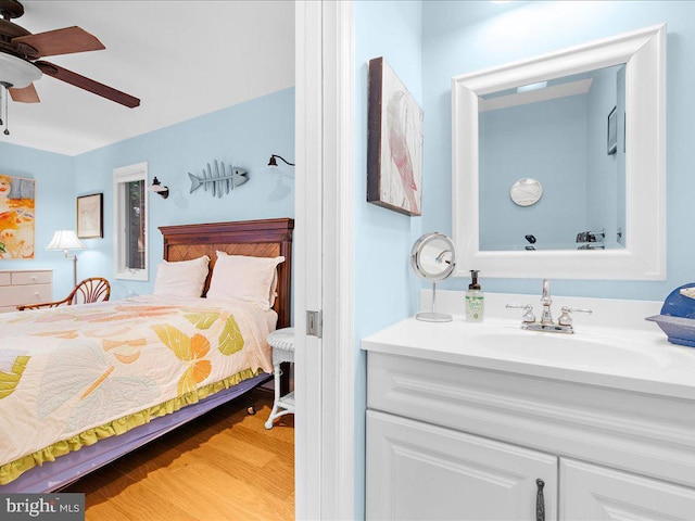bedroom with light wood-type flooring, a sink, and ceiling fan