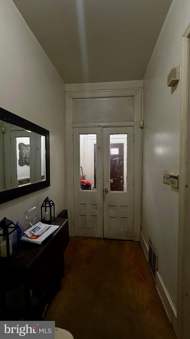 carpeted foyer with baseboards