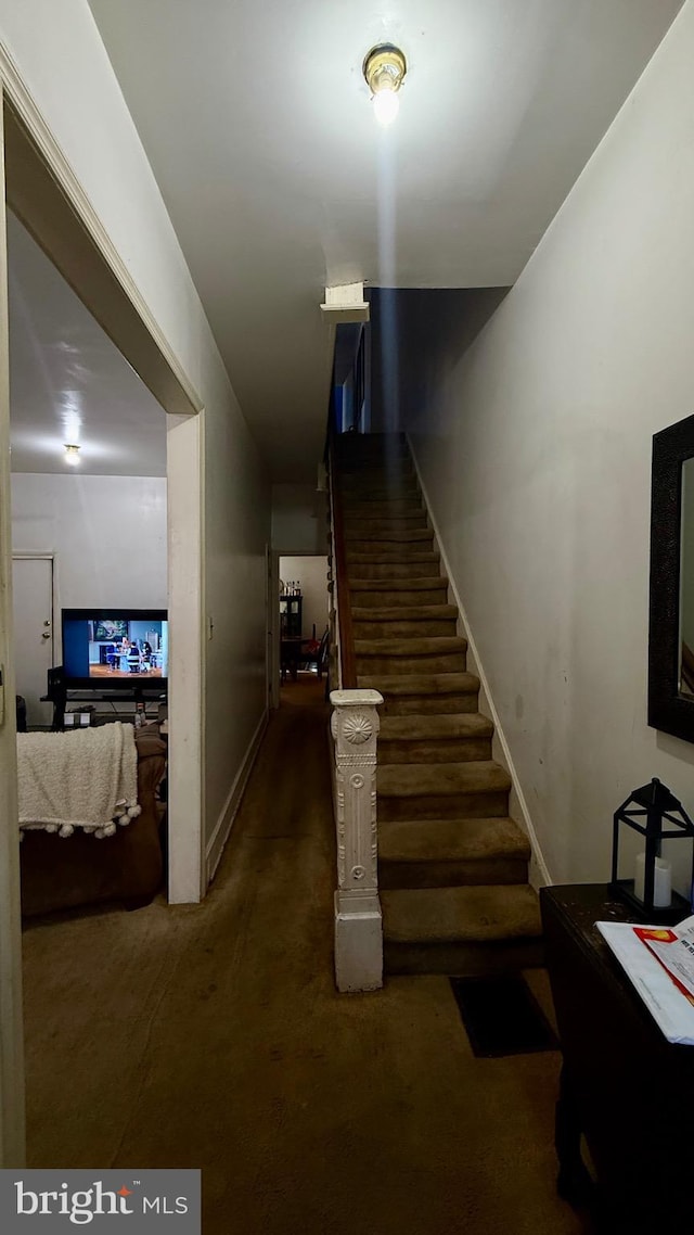 stairway featuring carpet flooring and baseboards