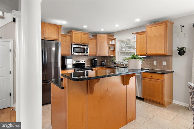 kitchen featuring a center island, decorative backsplash, a breakfast bar, and appliances with stainless steel finishes