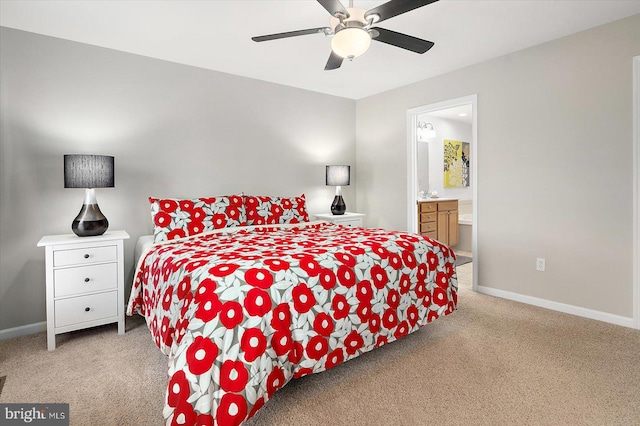 bedroom with ceiling fan, ensuite bath, baseboards, and light carpet