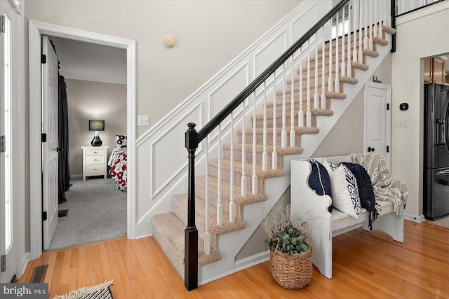 staircase with wood finished floors and visible vents