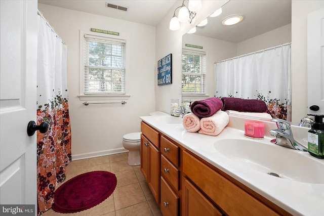 full bathroom with tile patterned floors, a sink, double vanity, toilet, and visible vents