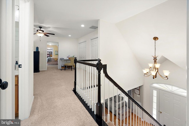 hallway featuring visible vents, carpet, an upstairs landing, a notable chandelier, and recessed lighting