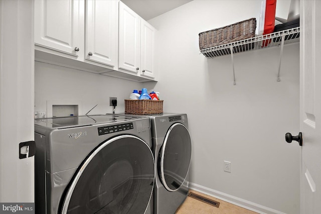 laundry room featuring separate washer and dryer, light tile patterned flooring, cabinet space, baseboards, and visible vents