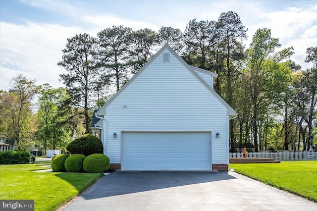 view of property exterior with driveway, fence, a yard, and a garage