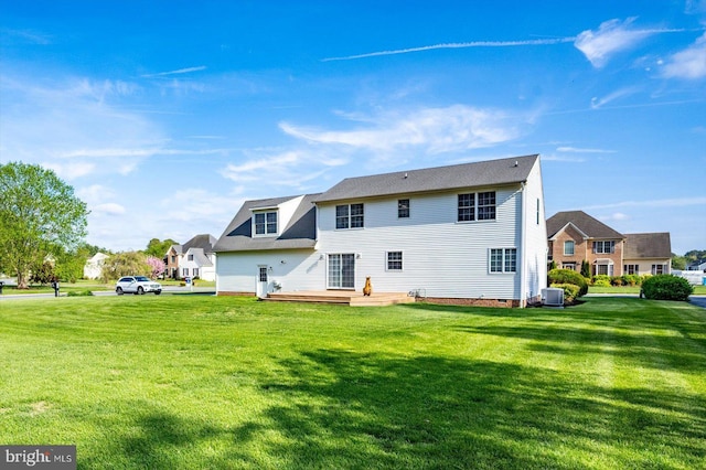 rear view of house with a lawn, central AC unit, crawl space, and a deck