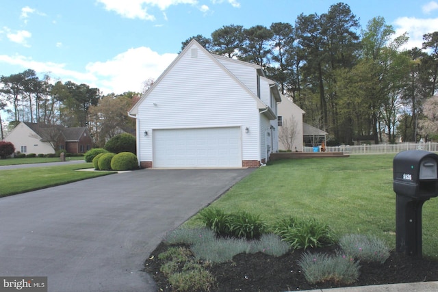 view of property exterior featuring fence, a lawn, driveway, and a garage