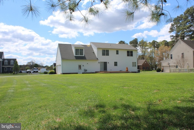 back of property featuring a lawn and a wooden deck