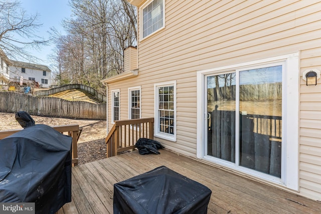 wooden terrace featuring area for grilling and fence