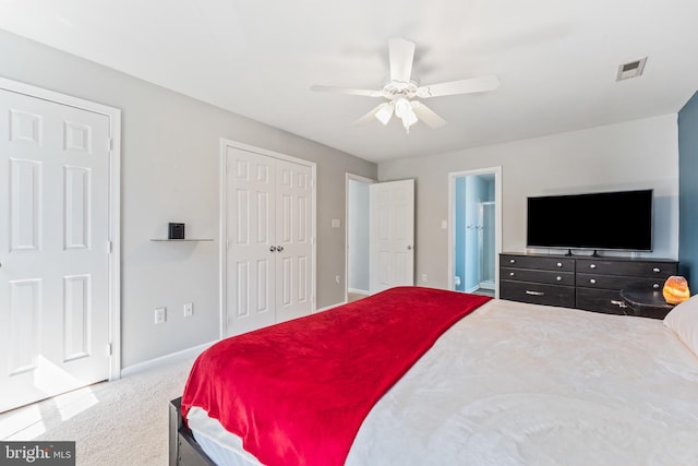 bedroom with carpet, baseboards, visible vents, a ceiling fan, and ensuite bathroom