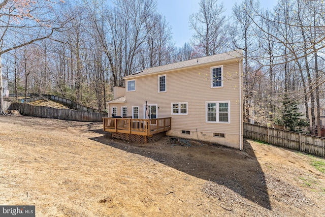 rear view of property featuring a fenced backyard and a wooden deck