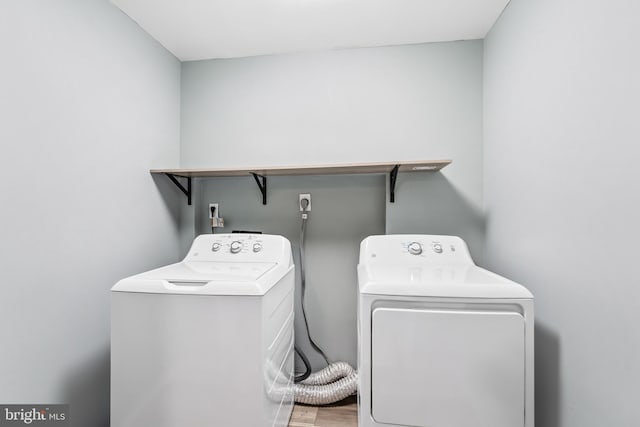 laundry area with washing machine and dryer, laundry area, and wood finished floors