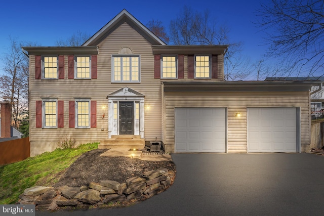 colonial house with driveway and a garage