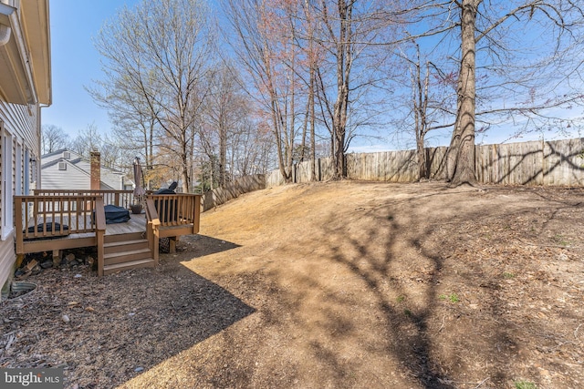 view of yard with a fenced backyard and a wooden deck