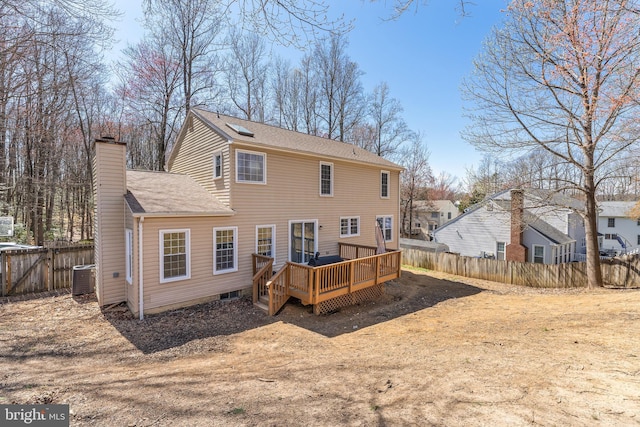 rear view of house featuring central air condition unit, a chimney, fence, a deck, and a shingled roof