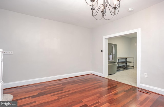 3524 Hickory Ave, Baltimore, MD 21211 - empty room with wood finished floors, baseboards, a chandelier, and visible vents
