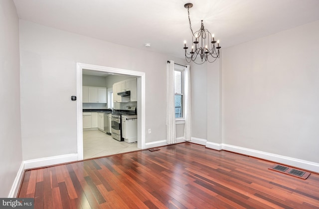 3524 Hickory Ave, Baltimore, MD 21211 - unfurnished dining area featuring an inviting chandelier, baseboards, light wood-style floors, and visible vents