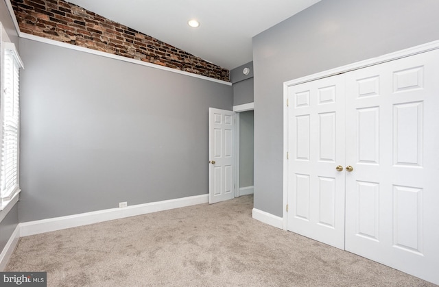 3524 Hickory Ave, Baltimore, MD 21211 - unfurnished bedroom featuring a closet, carpet floors, baseboards, and brick wall