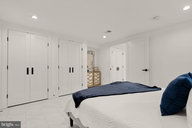 bedroom featuring multiple closets and recessed lighting