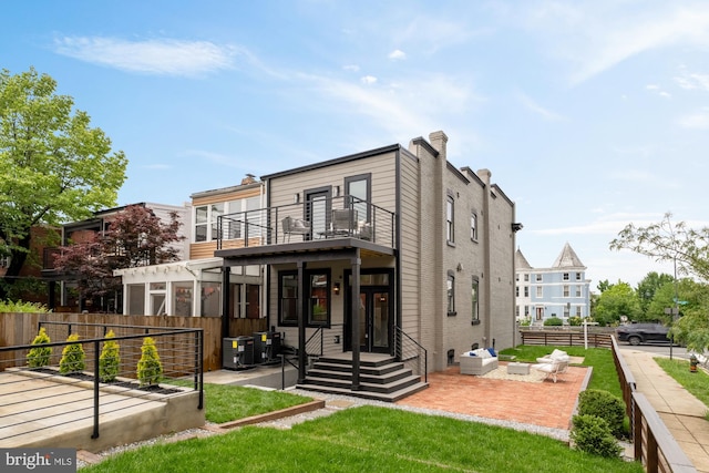 rear view of property featuring a balcony, a patio area, fence, and central air condition unit