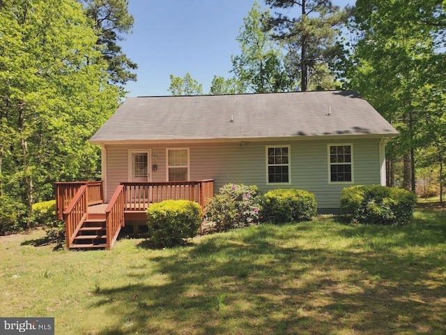 back of property with a deck and a yard