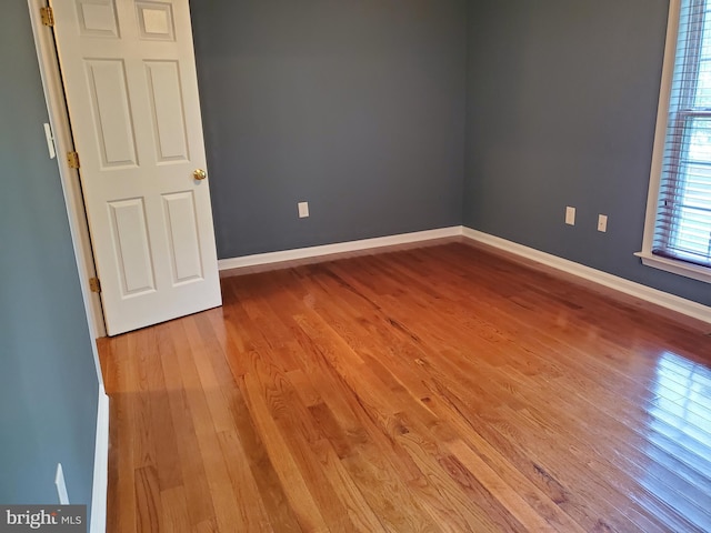 unfurnished room featuring baseboards and wood finished floors