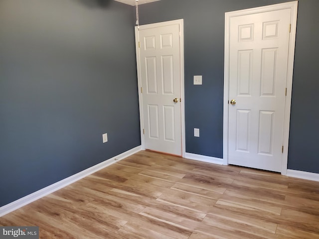 unfurnished bedroom featuring baseboards and light wood-type flooring
