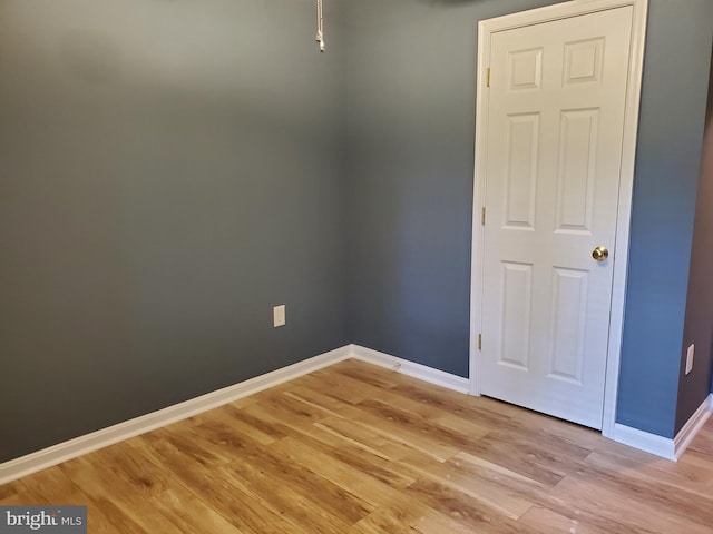 empty room featuring baseboards and light wood-style flooring