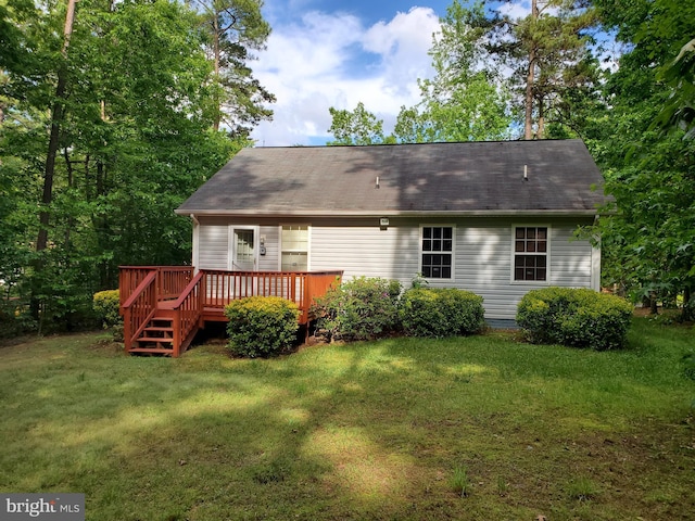back of property with a wooden deck and a yard
