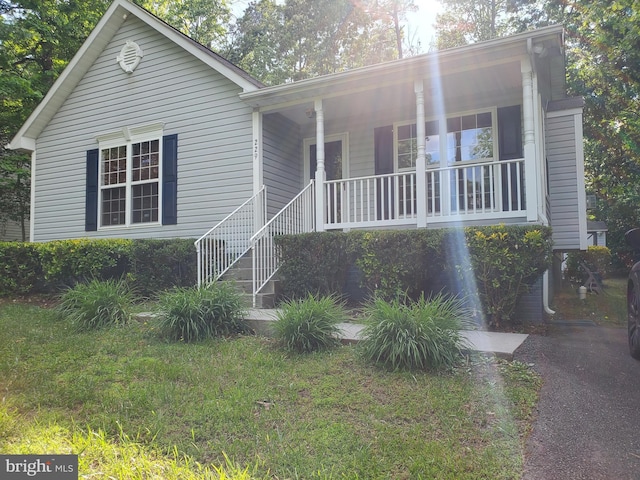 view of front of home featuring covered porch and a front yard