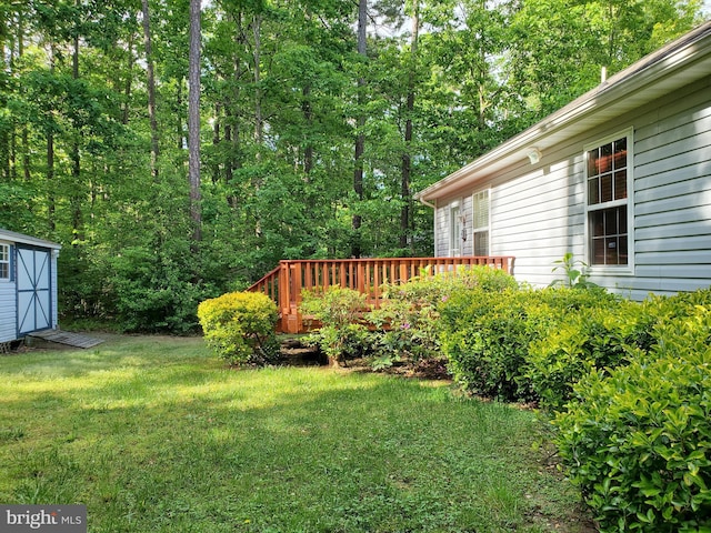view of yard featuring an outdoor structure, a storage unit, and a wooden deck