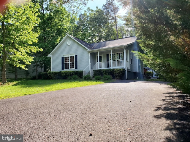 single story home with covered porch, a front yard, and driveway